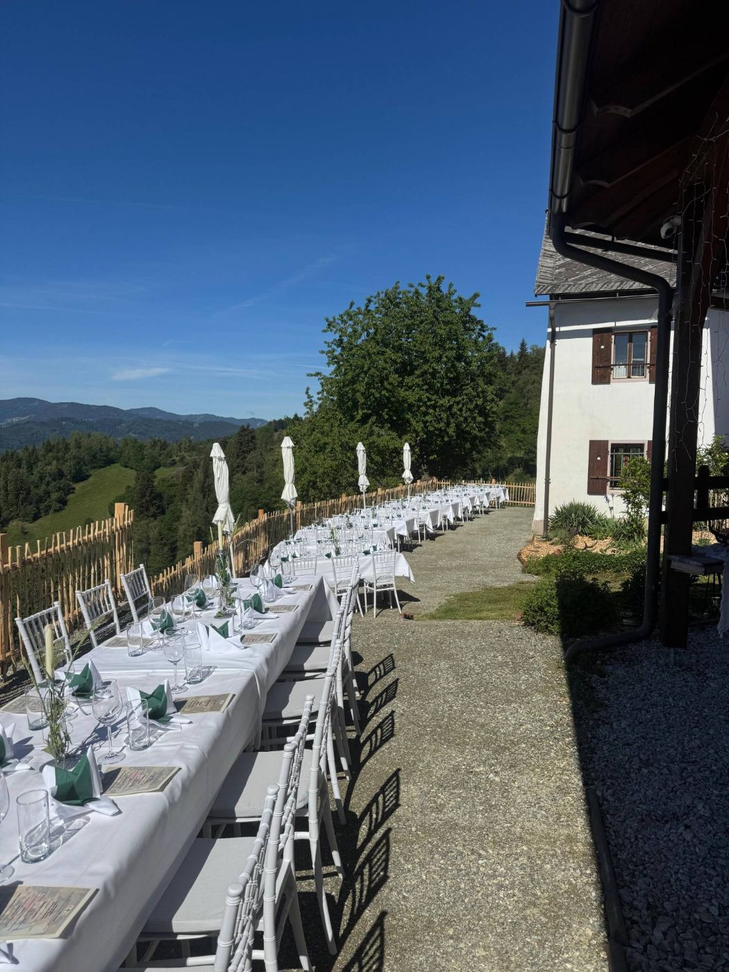 Lange weiß gedeckte Festtafel entlang des Holzzauns
