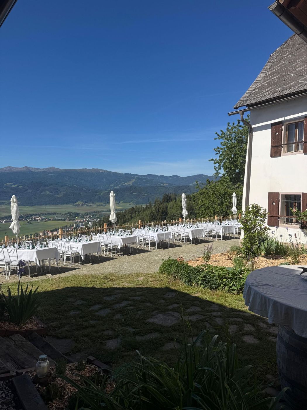 Gedeckte Tische auf der Terrasse mit Blick über das Tal